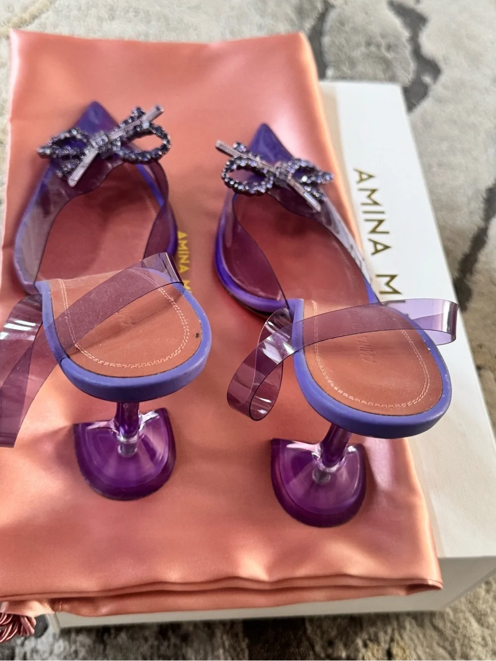 Amina Muaddi Purple Clear Slingback Heels with Crystal Bow